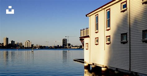 White And Brown Concrete Building Beside Body Of Water During Daytime Photo Free Calm Image On