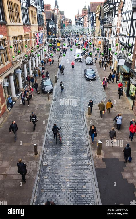 Male And Female Shoppers Walking Along Eastgate Street Chester England