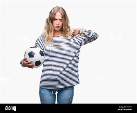 Schöne junge blonde Frau mit Fußball Fußball Kugel über isolierte Hintergrund mit Verärgerten