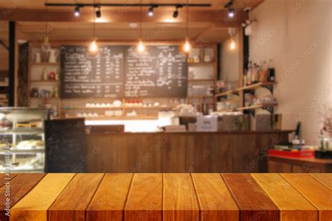 Wooden Table Top With Blur Of Coffee Shop Interior Or Background Cafe