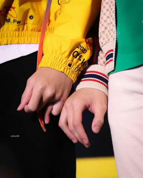 Two People Wearing Yellow Jackets And Black Pants With Their Hands On