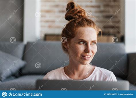 Image Of Focused Woman Working With Laptop While Sitting On Floor Stock