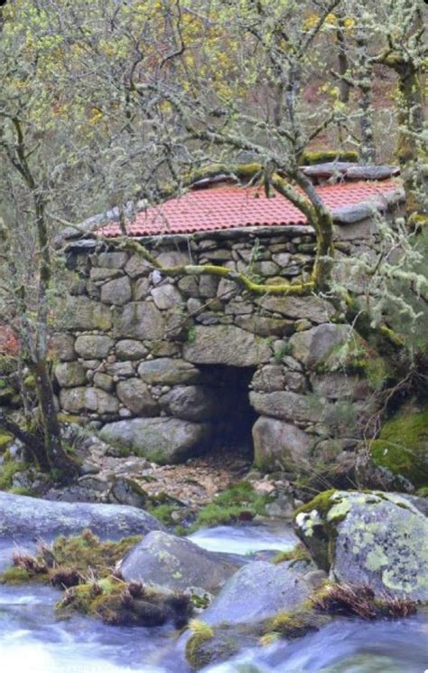 A Small Stone Structure With A Red Roof In The Middle Of Some Rocks And