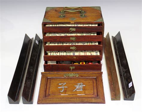 A Chinese Mahjong set, mid-20th century, with bone and bamboo tiles, within a brass mounted hardwood