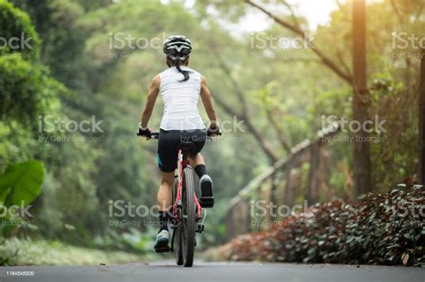 Woman Cyclist Riding Mountain Bike On Tropical Rainforest Trail Stock