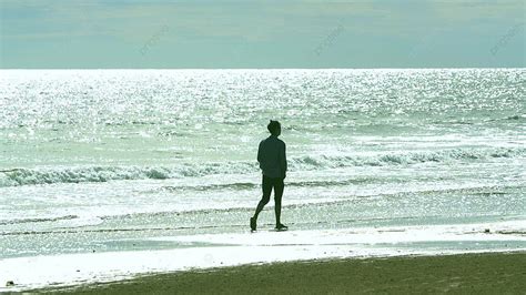 Tiro Real De Contraluz De Un Hombre Caminando En La Playa Fondos Tiro