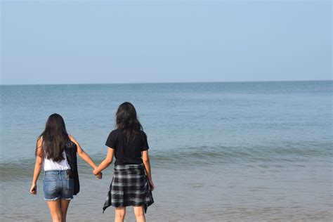 Two Girls Holding Hands At A Beach Pixahive