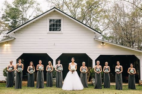 A Bride And Her Bridal Party In Front Of A Barn