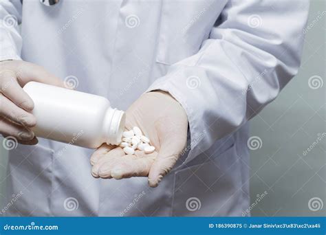 A Doctor Pouring Drug Tablets Into His Rubber Gloved Hand Stock Image