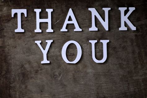 Thank You Word From White Wooden Letters On Table And Hands Stock Photo