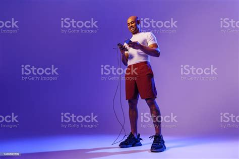 Young Sporty Man Is Check Fitness App And Holding Jump Rope Standing On