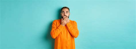 Frightened Man In Orange Sweater Reacts To Terrifying Scene Photo