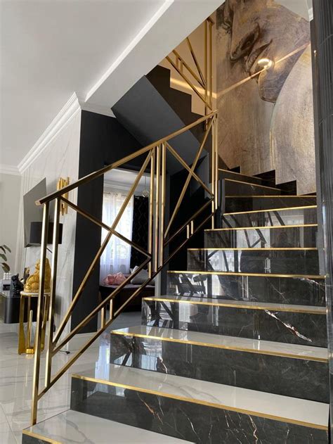 A Marble Staircase With Gold Railings In A Modern Style Home Featuring