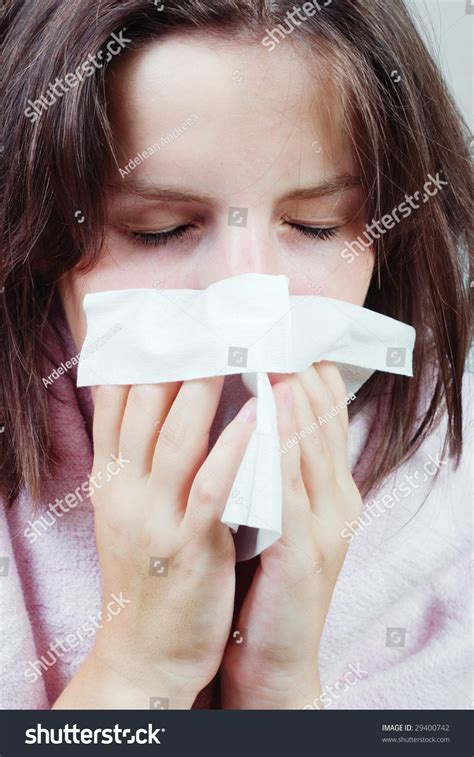 A Young Woman Sneezing With A Tissue In Her Hands Stock Photo 29400742