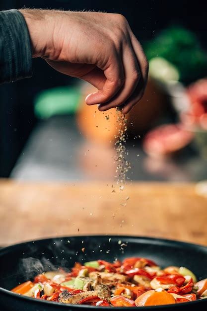 Premium Photo Seasoning Chef Sprinkling Oregano Over Vegetables