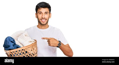 Young Handsome Man Holding Laundry Basket Smiling Happy Pointing With