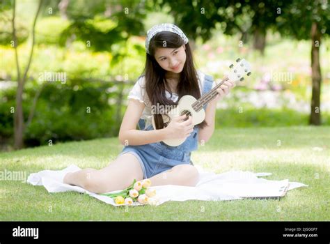 Happiness Young Asian Woman Sitting And Playing Ukulele While