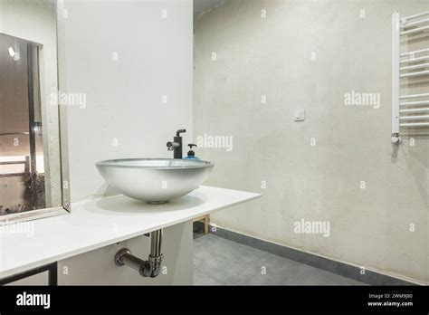 White Countertop Of A Small Bathroom With A Silver Colored Semicircular