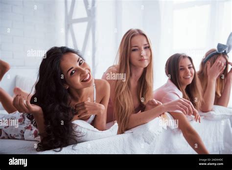 Les filles de joie dans la lingerie allongé sur le lit en salle blanche et avons célébration