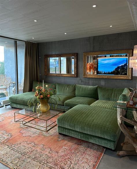 A Living Room Filled With Green Couches Next To A Large Glass Window