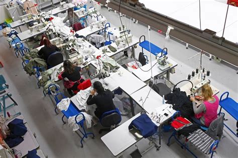 Several People Are Sitting At Tables In A Room Full Of Sewing Machines