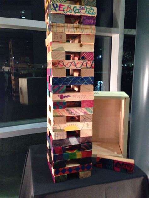 A Tall Tower Made Out Of Wooden Blocks Sitting On Top Of A Table