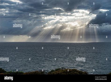 Bright Morning Sunlight Shining Through Hole In The Clouds Over The Sea