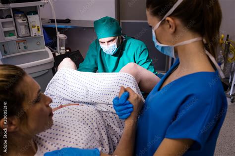 Medical team examining pregnant woman during delivery Stock Photo ...