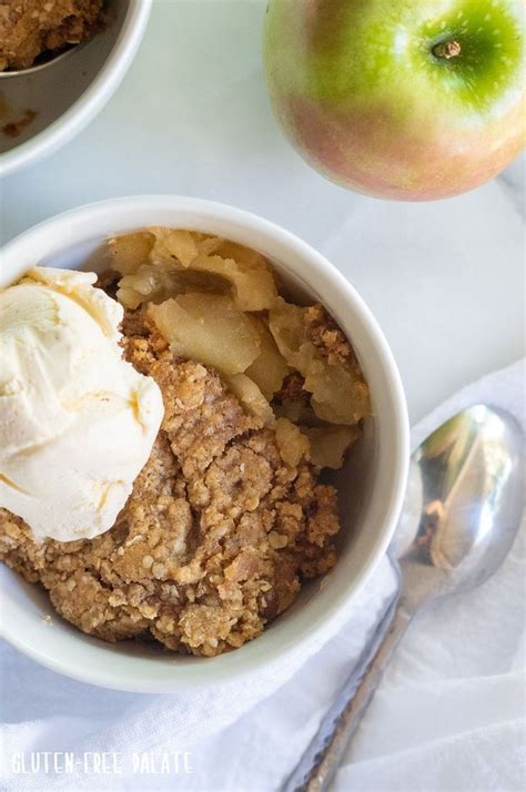 Two Bowls Filled With Apple Crisp And Ice Cream Next To An Apple On The