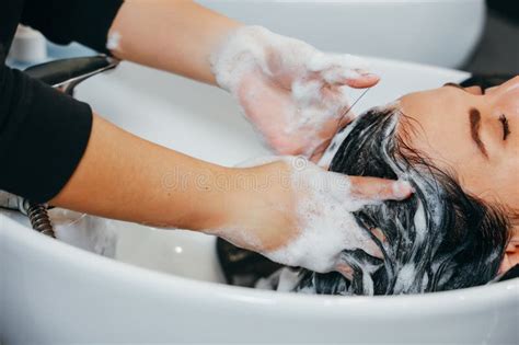 Hairdresser Shampooing His Client Hair At A Sink In A Barber Shop