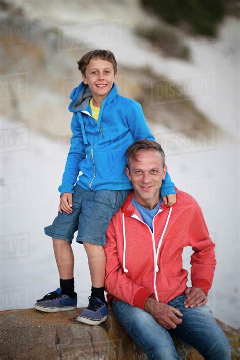 Caucasian Father And Son Smiling On Beach Stock Photo Dissolve