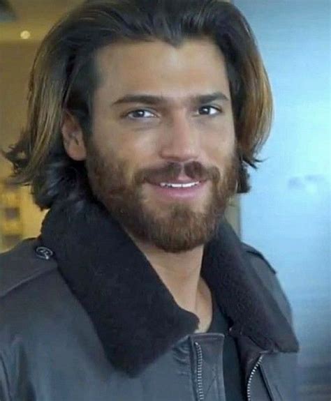 A Man With Long Hair And Beard Wearing A Leather Jacket Smiles At The