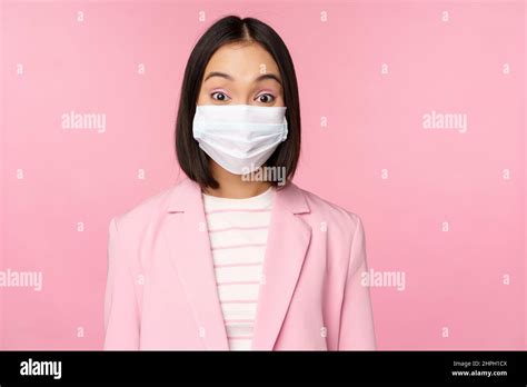 Portrait Of Asian Businesswoman In Medical Face Mask Wearing Suit