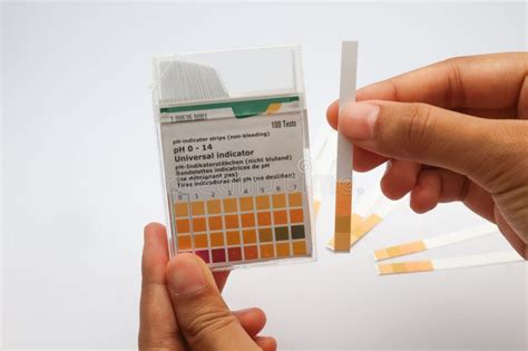 A Hand Holding PH Indicator Test Strips Indicates The Method Of