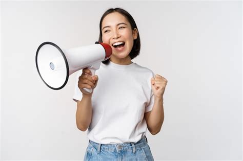 Menina asiática gritando no megafone jovem ativista protestando usando