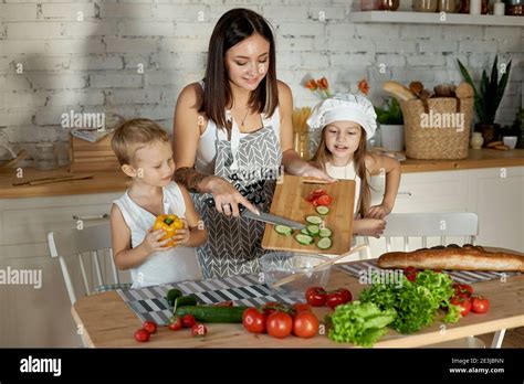 Mom cooks lunch with the kids. A woman teaches her daughter to cook ...