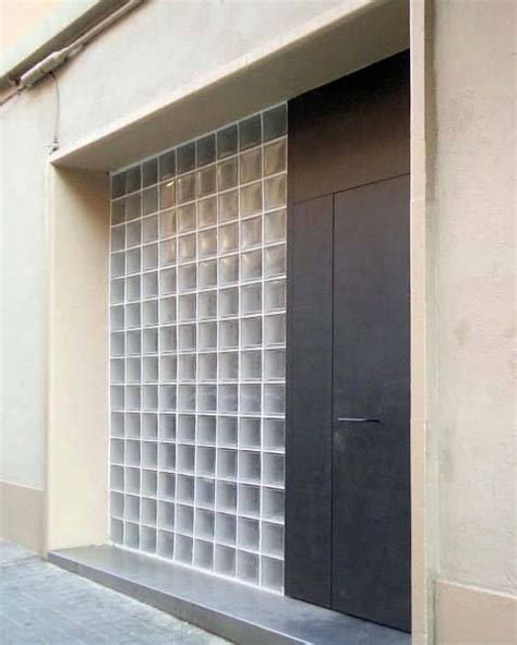 An Open Door On The Side Of A Building Next To A Window With Glass Blocks