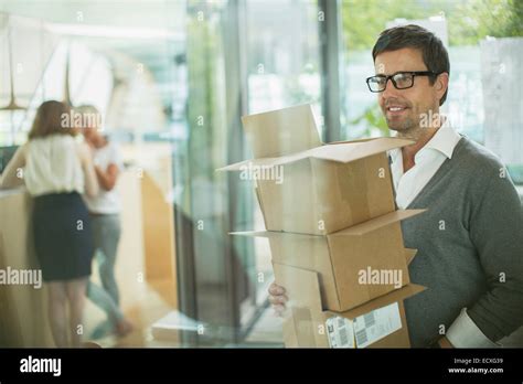 Businessman Carrying Cardboard Boxes In Office Stock Photo Alamy