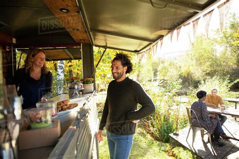 Food Cart Owner And Customer Talking In Park Stock Photo Dissolve