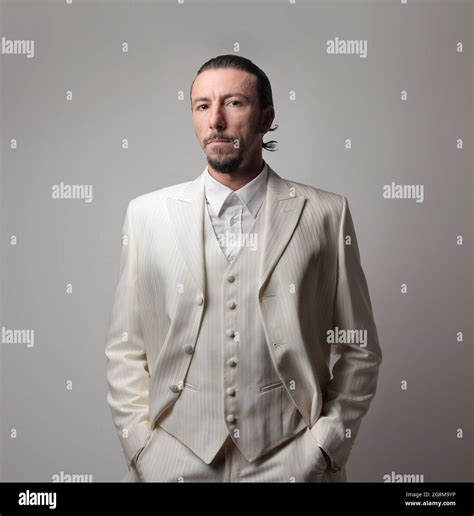 Portrait Of An Adult Italian Mafia Boss Wearing A White Suit Against A