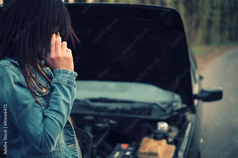 Woman With Brown Hair Under The Hood Of Her Car Break Down Stock Foto