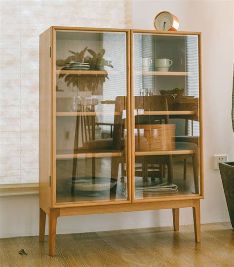 A Wooden Cabinet With Glass Doors On The Front And Side Next To A