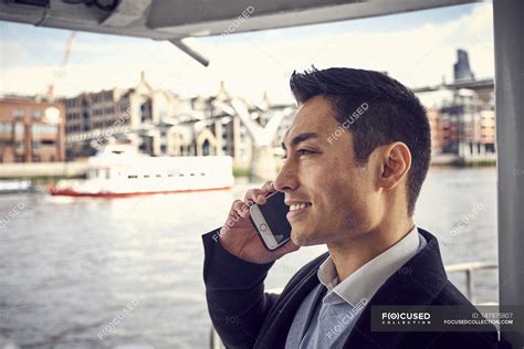 Man talking on mobile phone — cheerful, england - Stock Photo | #147975807