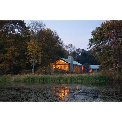 A House Sitting On Top Of A Lake Surrounded By Trees