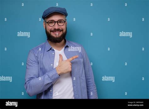 Studio Portrait Of Mature Caucasian Man With Glasses And Blue Cap With