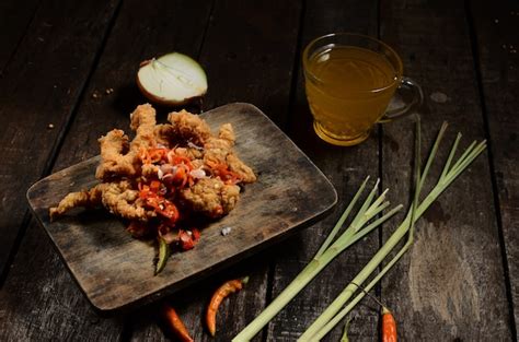 Premium Photo Crispy Fried Chicken Pieces And Sambal Matah Bali With A Glass Of Hot Orange On