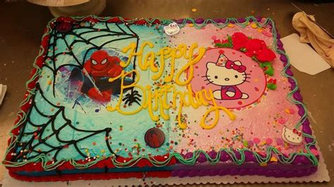 a hello kitty birthday cake with spiderman and cat on the side, sitting ...