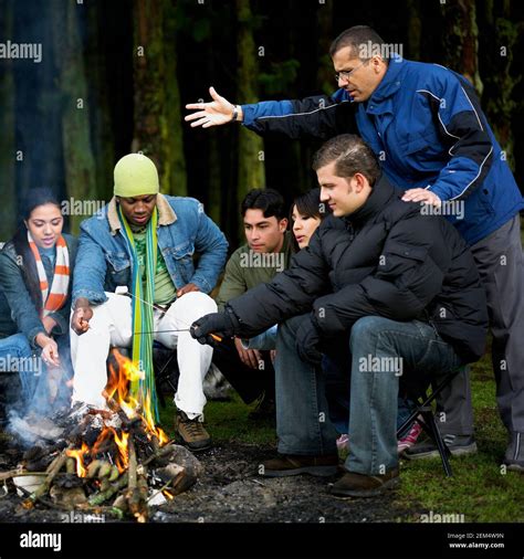 Group Of People Near Campfire In The Forest Stock Photo Alamy