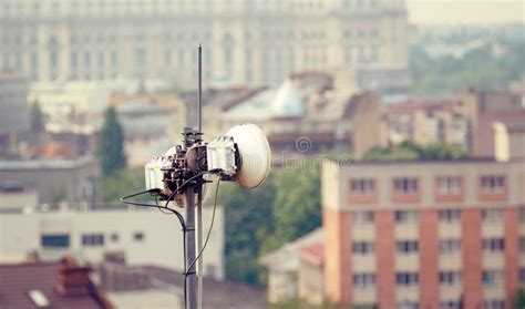 Telecommunication Microwave Antenna Dish On A Building Rooftop With The