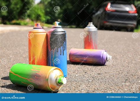 Latas Usadas De Pintura Con Aerosol En La Carretera Asfaltada